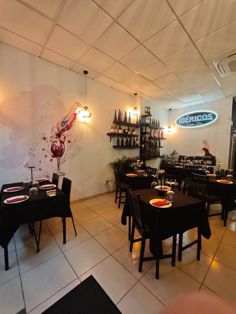Sala interior de Ibéricos Gastro-Bar con mesas preparadas y selección de vinos